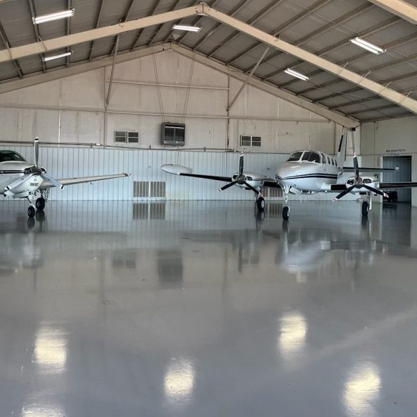 sleek, easy to clean urethane coatings on airplane hanger floor - photos also shows two private planes in the hanger